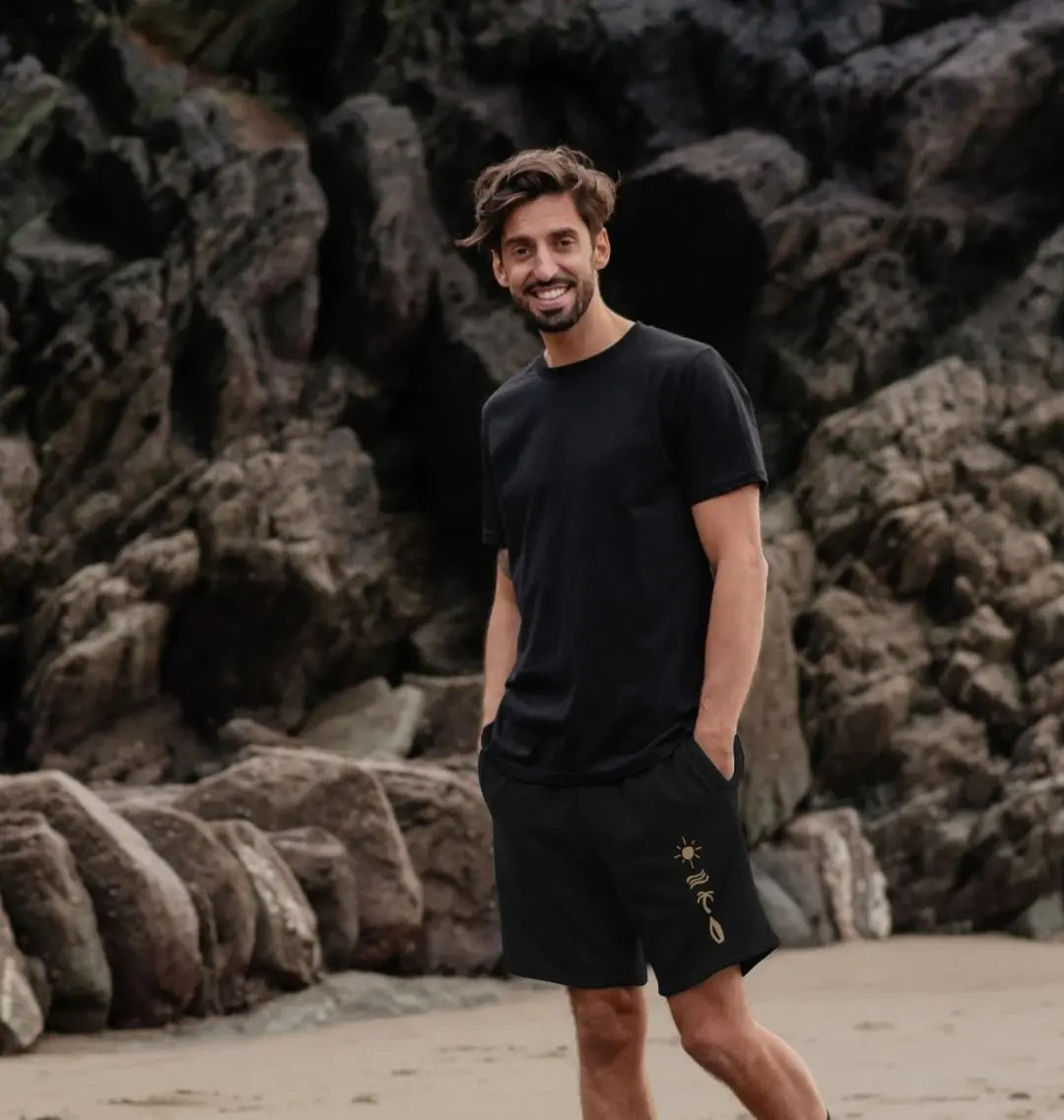 Beachscape men’s jogger shorts with sun, waves, palm tree and surfboard design in black