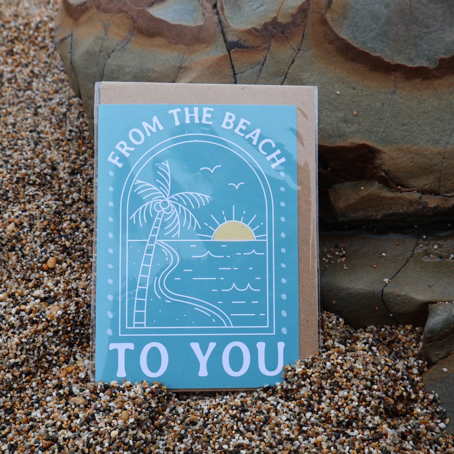 Card with 'From the Beach to You' text and palm tree design on a sandy background