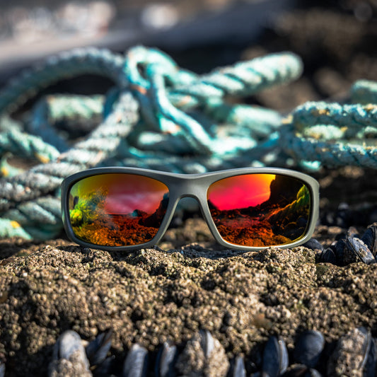 Waterhaul Mylor Raw wrap-around sunglasses with orange mirror effect on lens. Made from recycled ghost fishing gear. 
