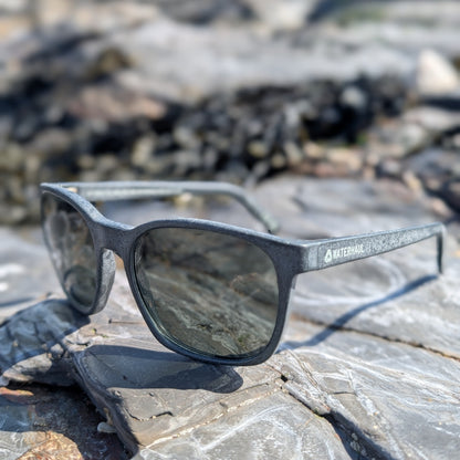 waterhaul recycled ghost net sunglasses sitting on a rock with the logo visible