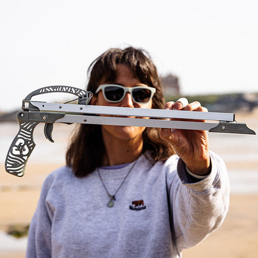 woman holding folded litter picker made from recycled marine waste