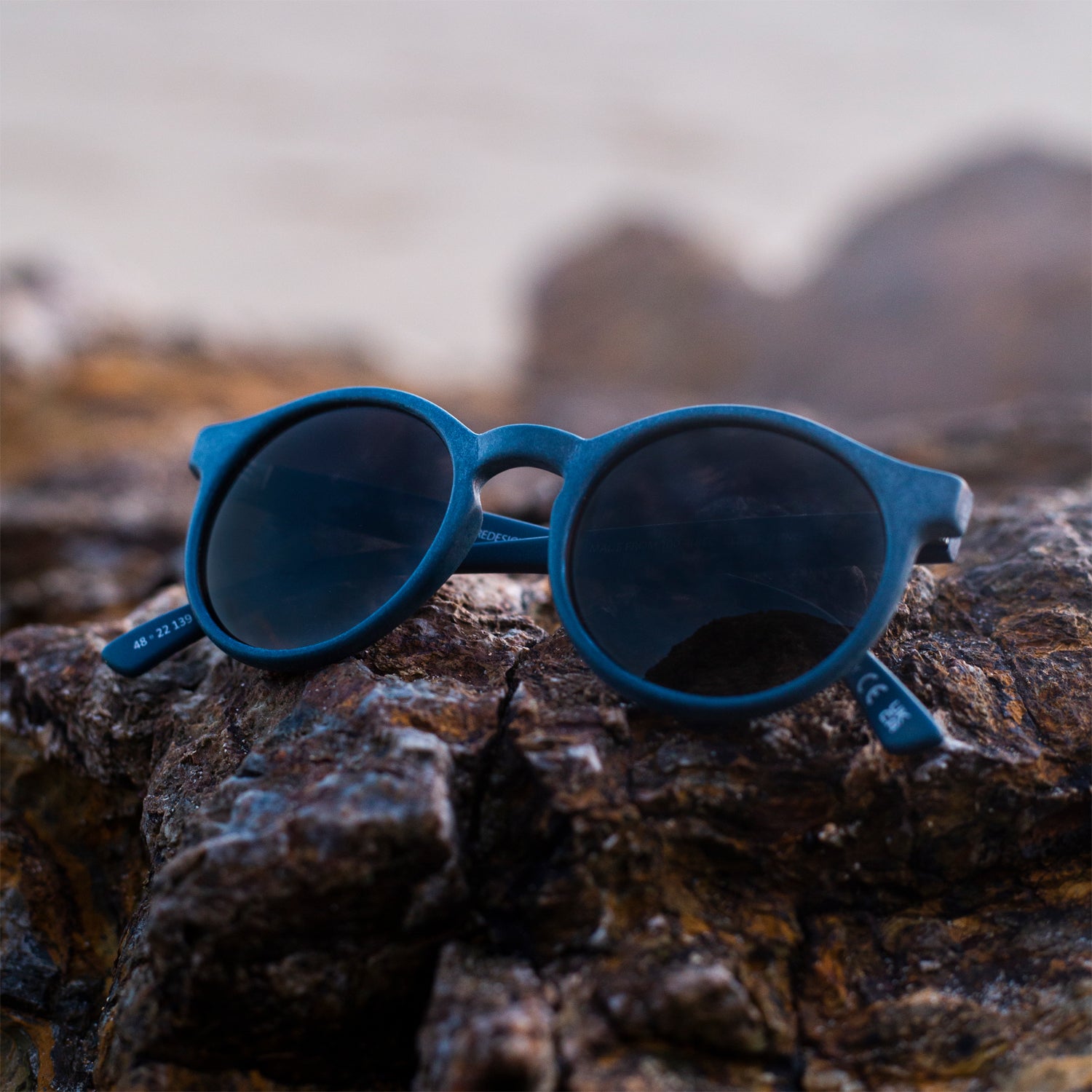 close up of navy rounded sunglasses made from recycled ocean waste
