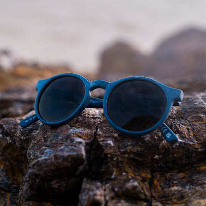 close up of navy rounded sunglasses made from recycled ocean waste