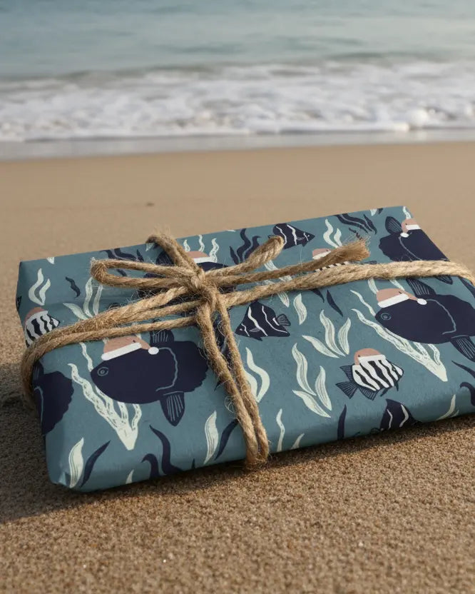 A sheet of eco-friendly wrapping paper with a Christmas-themed design featuring sunfish and other marine life, tied with a string and presented with a natural brown paper background.